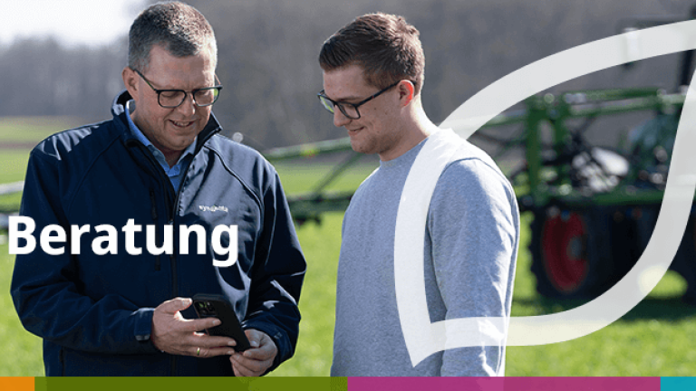 Zwei Männer im Gespräch vor Traktor; Text „Service &amp; Beratung“